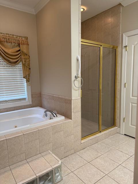 bathroom featuring tile patterned flooring, a bath, a stall shower, and ornamental molding