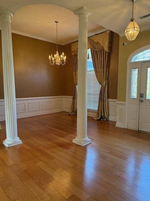 entrance foyer with light wood-type flooring, visible vents, ornamental molding, and ornate columns