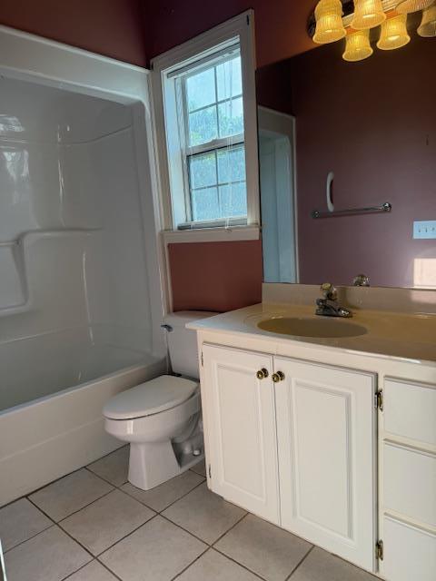 bathroom with tile patterned flooring, toilet, vanity, and bathing tub / shower combination