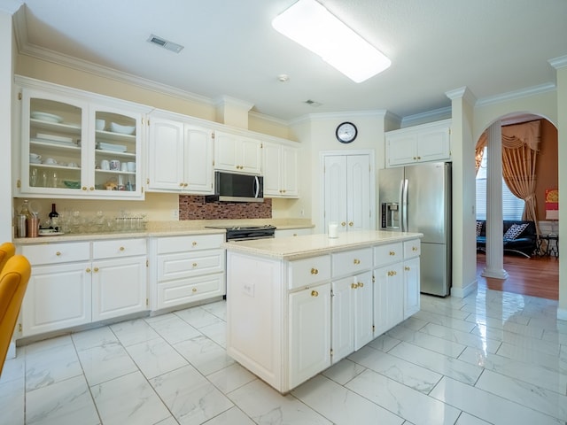 kitchen featuring a kitchen island, arched walkways, light countertops, appliances with stainless steel finishes, and marble finish floor