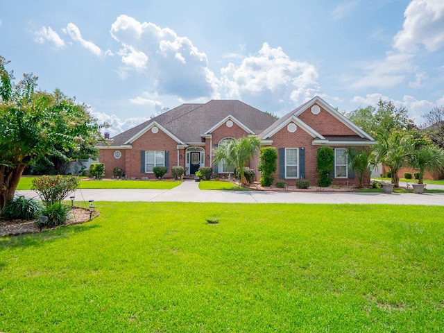 view of front facade featuring brick siding, concrete driveway, and a front lawn