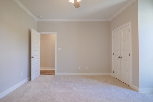 empty room with ceiling fan, light colored carpet, and ornamental molding