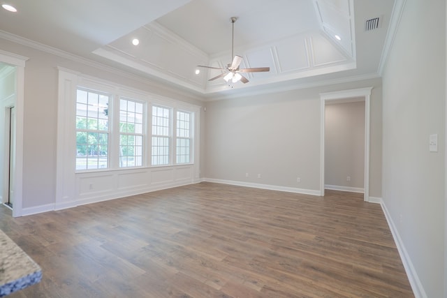 unfurnished room with a tray ceiling, ceiling fan, ornamental molding, and hardwood / wood-style flooring