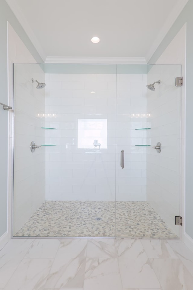 bathroom with ornamental molding and a shower with door