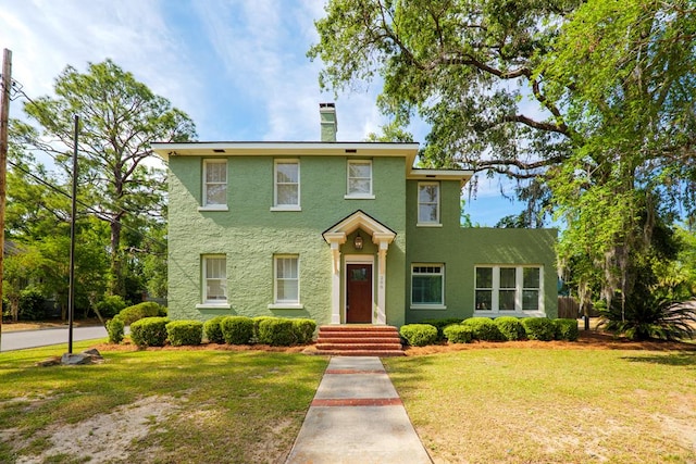 200 E College St, Valdosta, GA 31602 - colonial house featuring a chimney, a front yard, and stucco siding