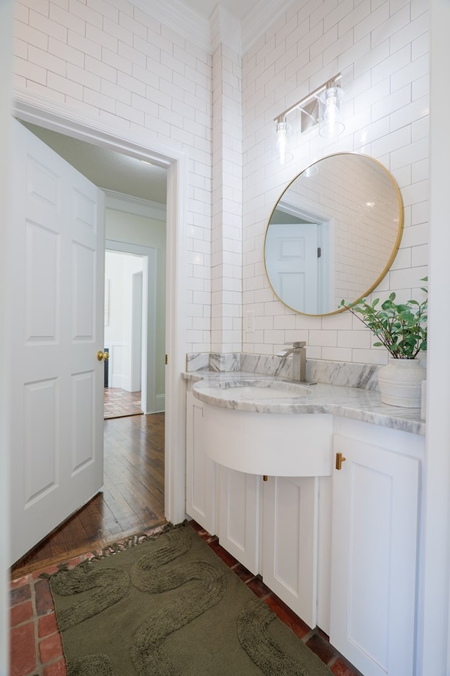 200 E College St, Valdosta, GA 31602 - bathroom with crown molding, wood finished floors, tile walls, and vanity