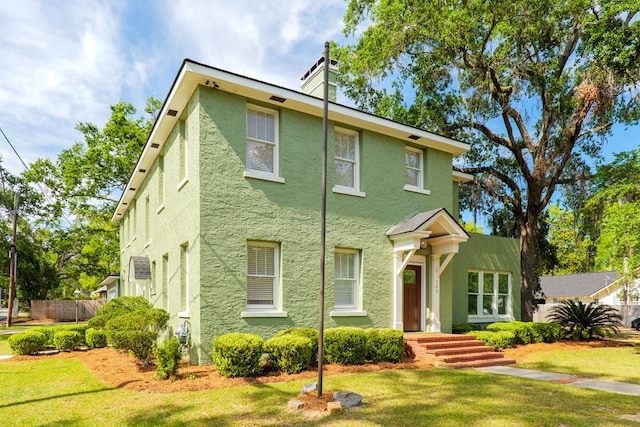 200 E College St, Valdosta, GA 31602 - view of front facade featuring fence, a chimney, a front yard, and stucco siding