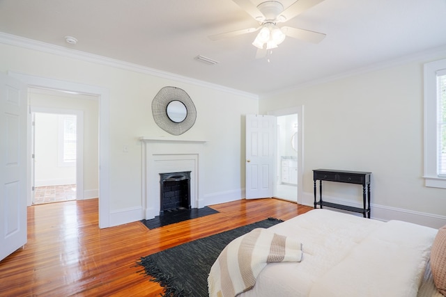 200 E College St, Valdosta, GA 31602 - bedroom with crown molding, baseboards, a fireplace with flush hearth, wood finished floors, and visible vents