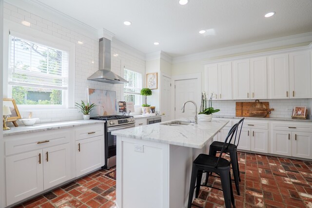 200 E College St, Valdosta, GA 31602 - kitchen with crown molding, a sink, brick floor, wall chimney exhaust hood, and stainless steel range with gas cooktop