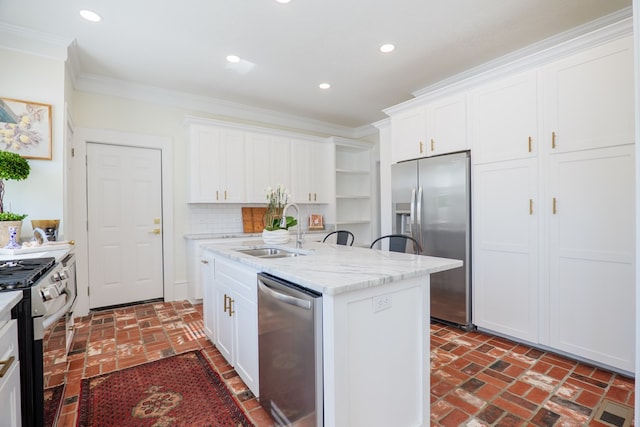 200 E College St, Valdosta, GA 31602 - kitchen with an island with sink, brick floor, white cabinets, a sink, and appliances with stainless steel finishes
