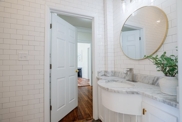 200 E College St, Valdosta, GA 31602 - bathroom with vanity, hardwood / wood-style floors, and tile walls