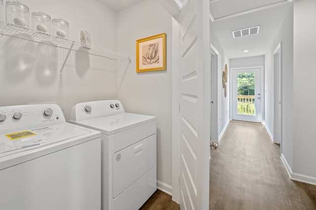 clothes washing area with laundry area, separate washer and dryer, dark wood-style flooring, visible vents, and baseboards