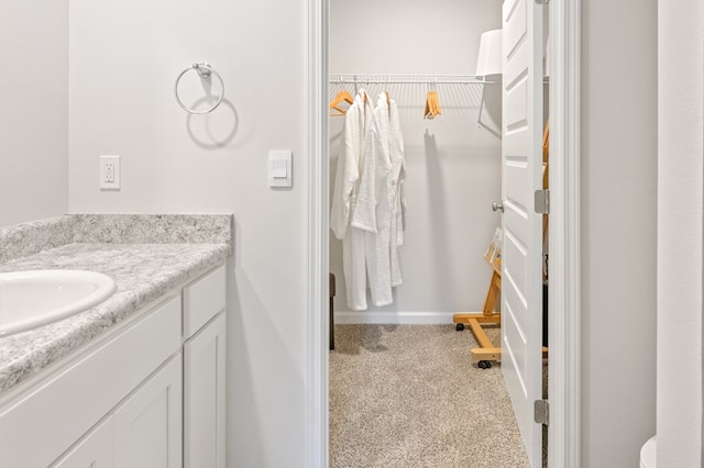 bathroom with vanity and a spacious closet