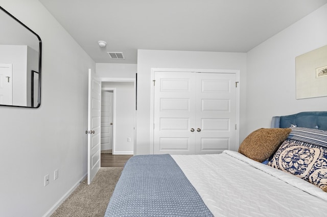 bedroom featuring a closet, carpet flooring, visible vents, and baseboards