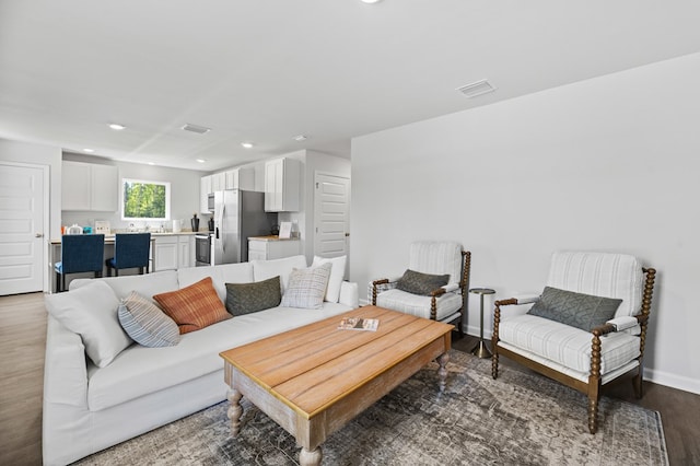 living area featuring baseboards, visible vents, wood finished floors, and recessed lighting