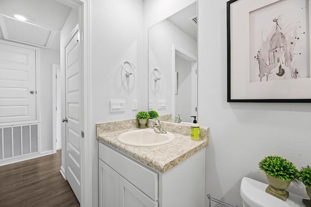 bathroom featuring toilet, visible vents, wood finished floors, and vanity