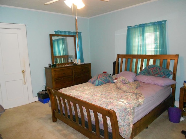 bedroom featuring ornamental molding, light carpet, and ceiling fan