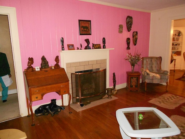 living room with a fireplace, ornamental molding, and wood finished floors