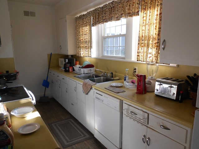 kitchen with white dishwasher, a sink, visible vents, white cabinets, and light countertops