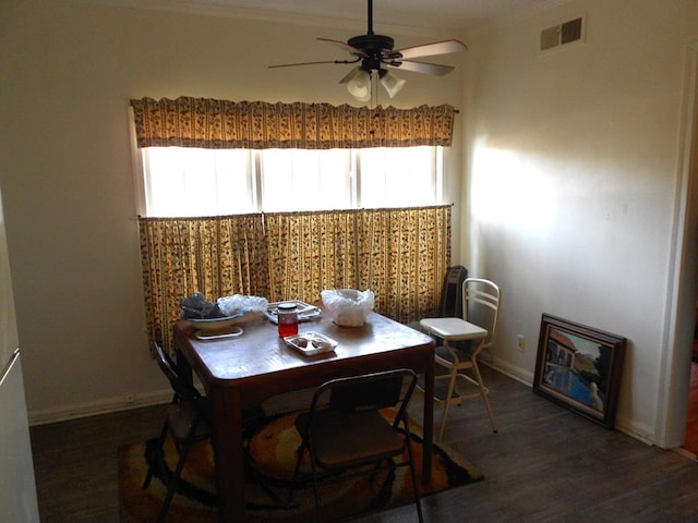 dining room featuring visible vents, baseboards, dark wood-style floors, ceiling fan, and crown molding