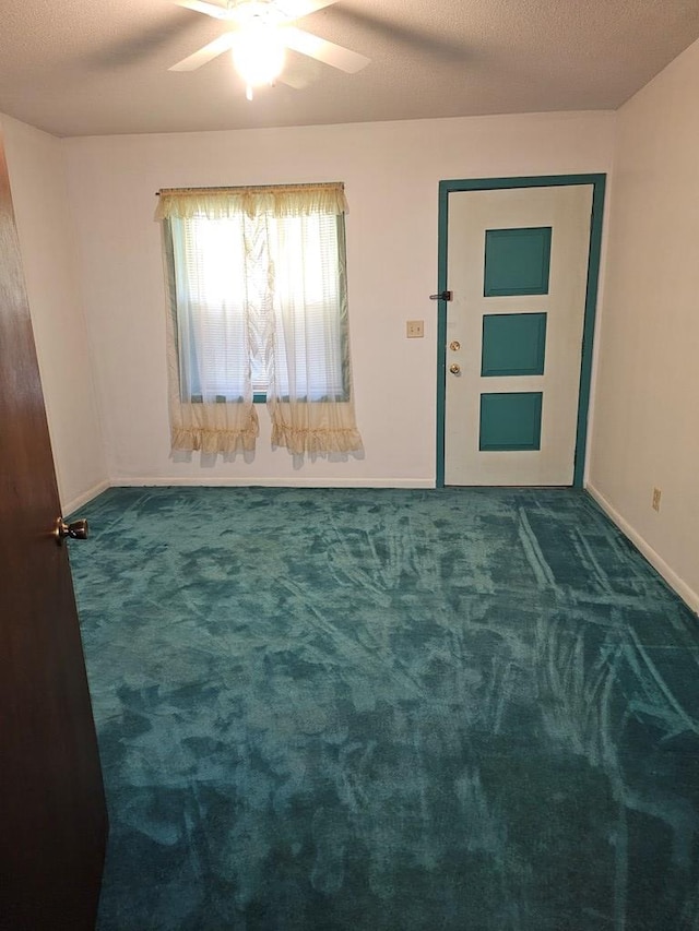 carpeted empty room featuring a ceiling fan and baseboards