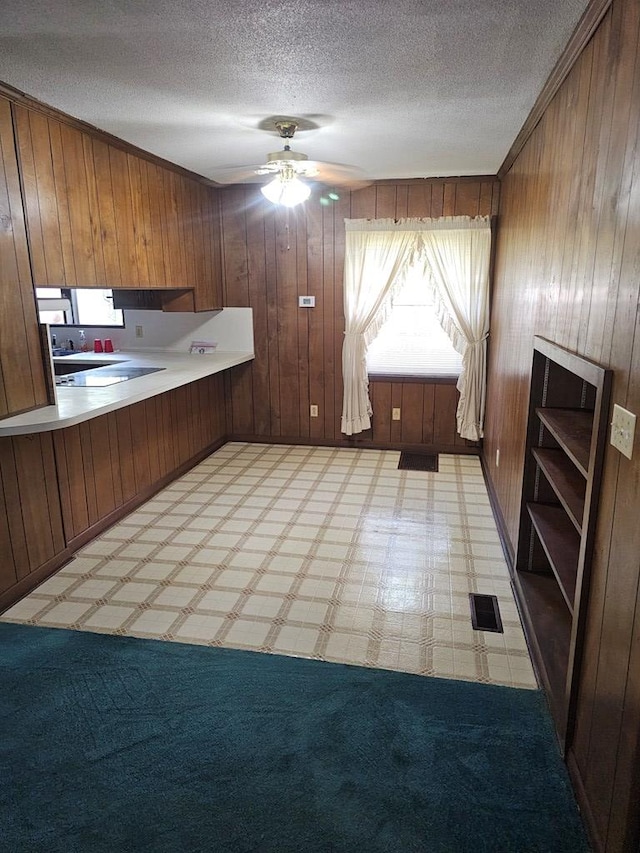 kitchen featuring wooden walls, visible vents, and light floors