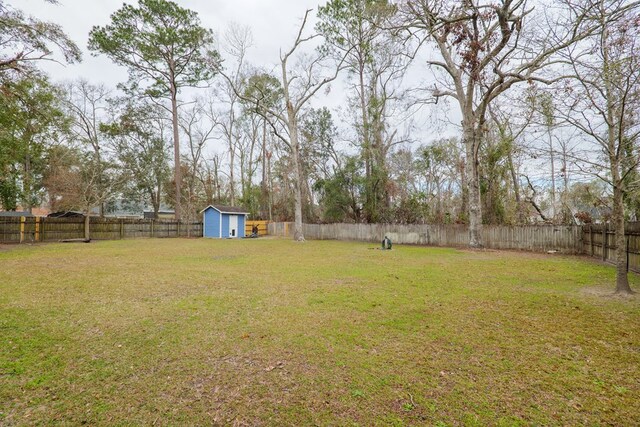 view of yard featuring an outbuilding, a storage shed, and a fenced backyard