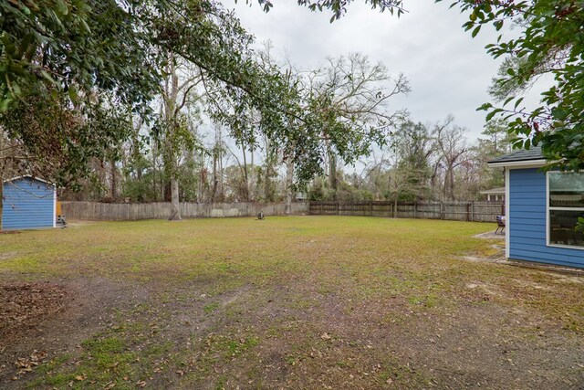 view of yard featuring an outdoor structure and a fenced backyard
