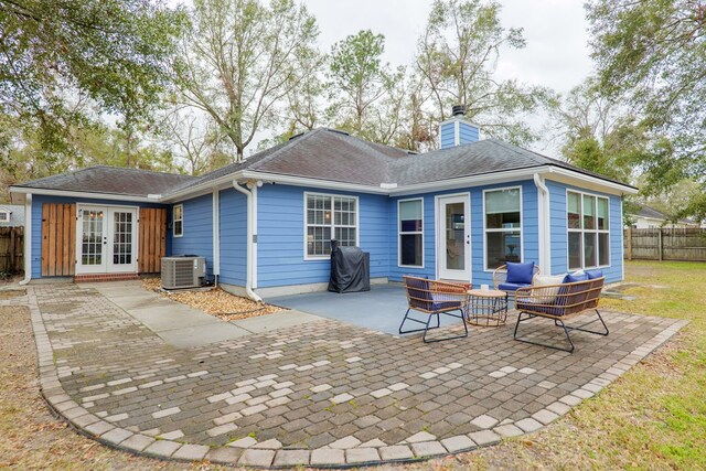 rear view of house with fence, roof with shingles, a chimney, french doors, and a patio area
