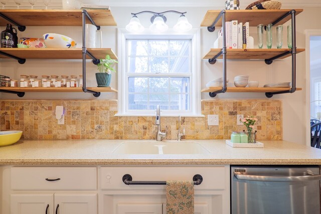 kitchen featuring white cabinetry, open shelves, a sink, dishwasher, and tasteful backsplash