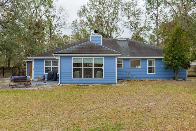 rear view of property with a patio, fence, a yard, a shingled roof, and a chimney