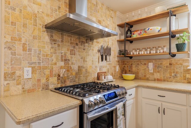 kitchen with light stone countertops, white cabinetry, gas range, exhaust hood, and tasteful backsplash