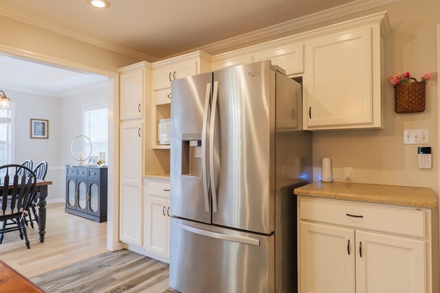 kitchen featuring recessed lighting, stainless steel refrigerator with ice dispenser, white cabinetry, crown molding, and light wood-type flooring