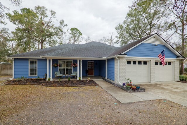 ranch-style house featuring brick siding, a shingled roof, concrete driveway, covered porch, and a garage