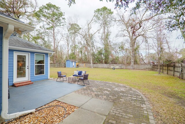 view of patio with an outdoor structure, a fenced backyard, and a shed