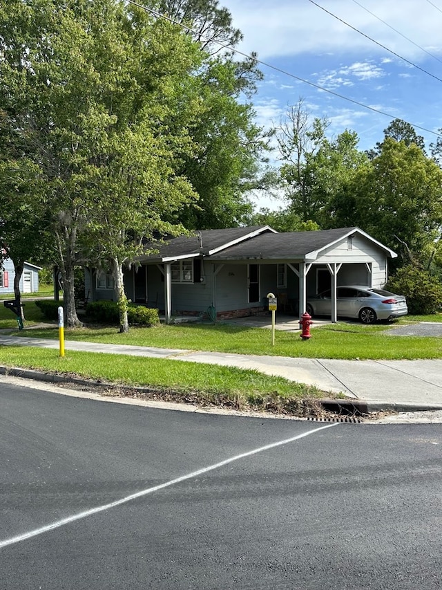 single story home with a front yard and a carport