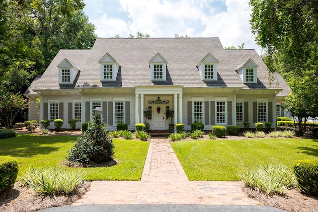 cape cod home with a front lawn