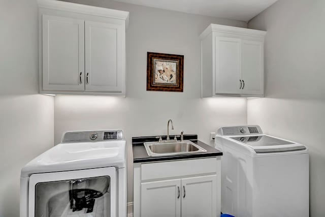 laundry area with separate washer and dryer, a sink, and cabinet space