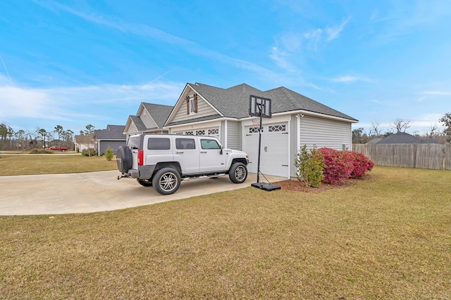 view of front of house with a front yard, concrete driveway, fence, and an attached garage