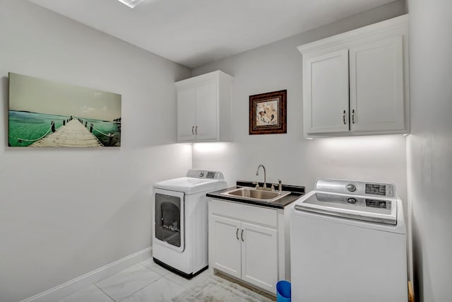 clothes washing area featuring washing machine and dryer, a sink, baseboards, marble finish floor, and cabinet space