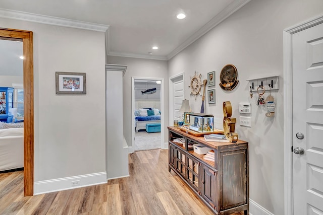 corridor with light wood-style floors, recessed lighting, crown molding, and baseboards