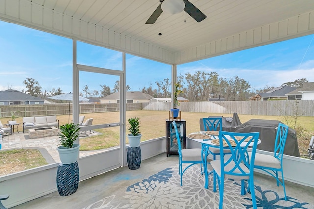 sunroom featuring a residential view and ceiling fan