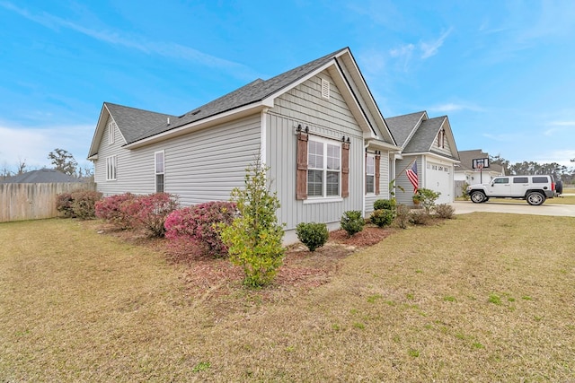 view of home's exterior with a garage, driveway, fence, and a lawn