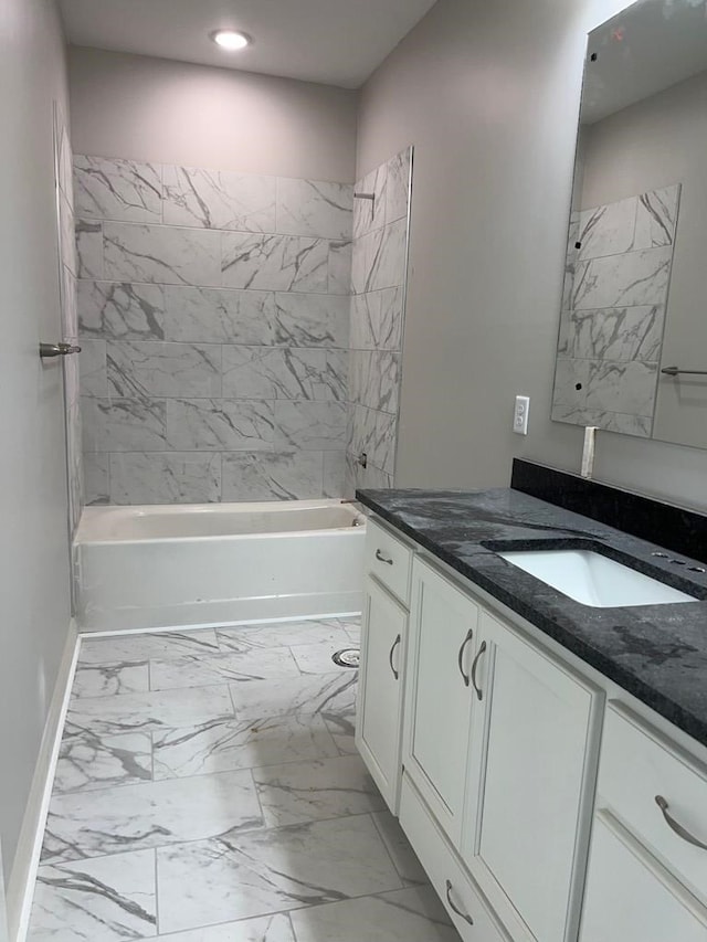 bathroom featuring vanity and tiled shower / bath