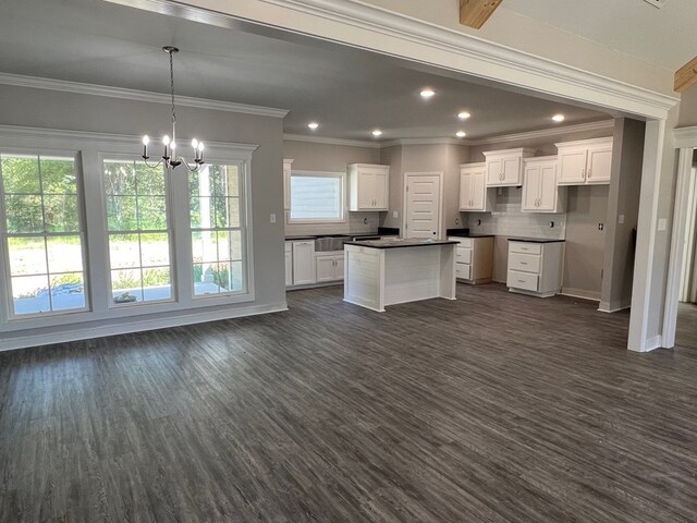 kitchen with white cabinets, decorative backsplash, dark hardwood / wood-style floors, and crown molding