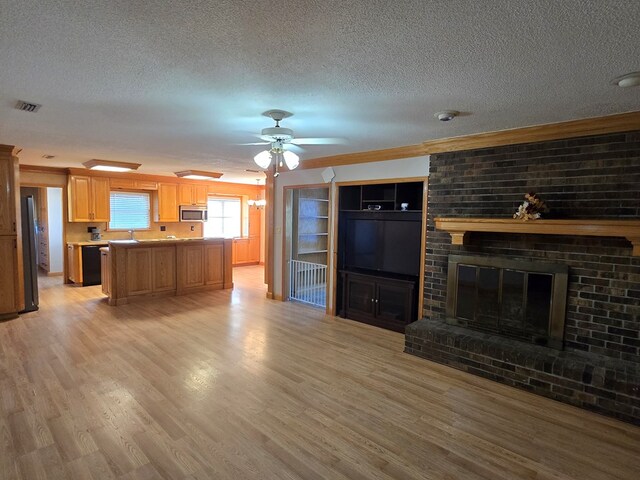 617 Ledgedale Cir, Valdosta, GA 31602 - unfurnished living room featuring a textured ceiling, light wood-style flooring, ornamental molding, ceiling fan, and a brick fireplace