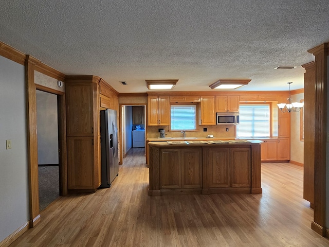 617 Ledgedale Cir, Valdosta, GA 31602 - kitchen with stainless steel appliances, light wood-type flooring, a chandelier, a textured ceiling, and crown molding