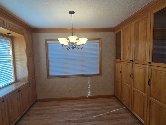 617 Ledgedale Cir, Valdosta, GA 31602 - unfurnished dining area with wood finished floors, a chandelier, ornamental molding, and a textured ceiling