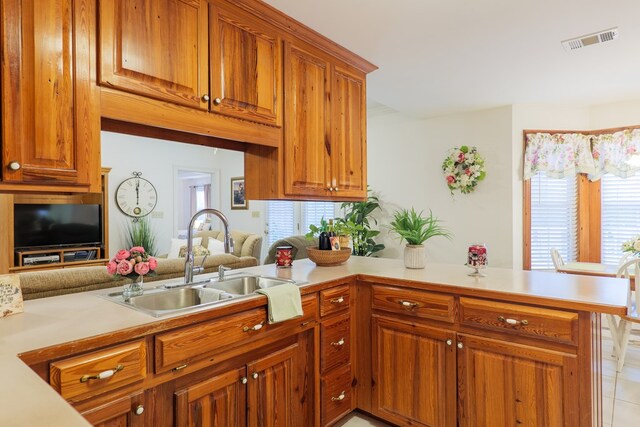 kitchen featuring sink, light tile patterned flooring, and kitchen peninsula