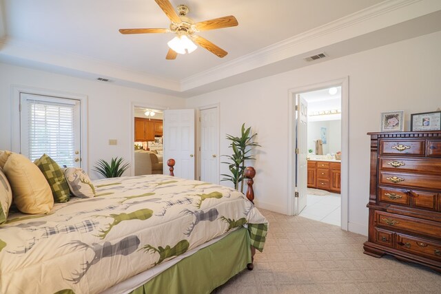 bedroom featuring ensuite bathroom, a tray ceiling, crown molding, ceiling fan, and light carpet